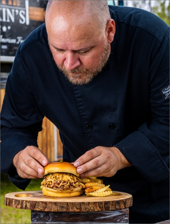 Chef Alex plating a burger at Latin Fixin's